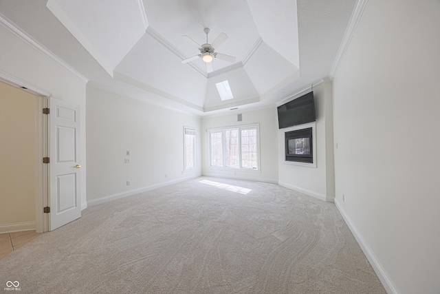 unfurnished living room featuring ornamental molding, a tray ceiling, and light colored carpet