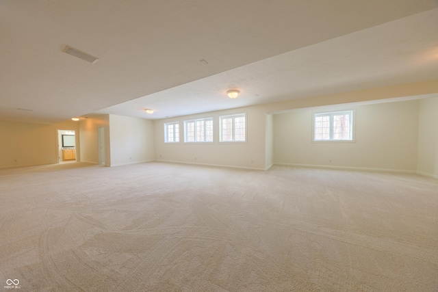 below grade area featuring light carpet and baseboards