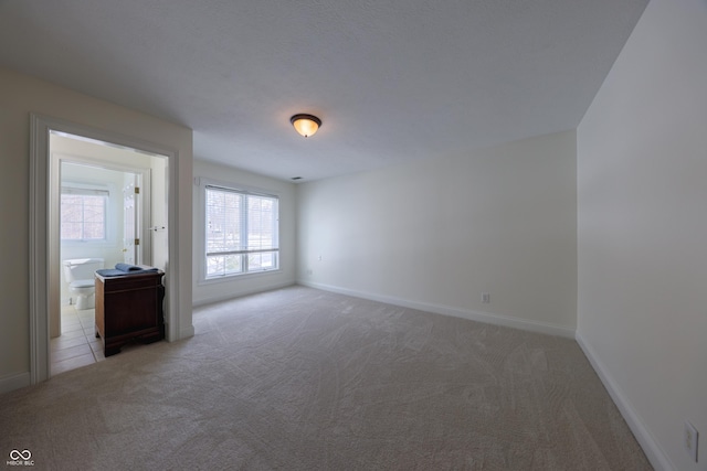 carpeted empty room with baseboards