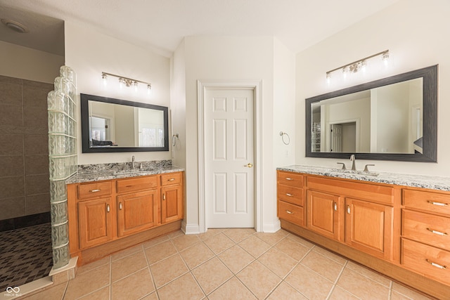 bathroom with a walk in shower, two vanities, tile patterned flooring, and a sink