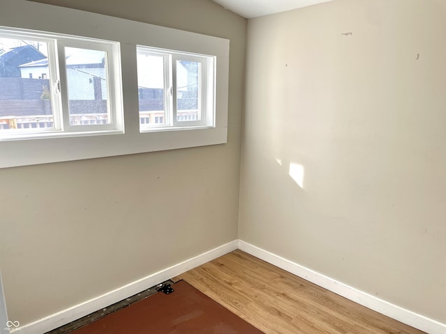 spare room featuring light wood-style flooring and baseboards