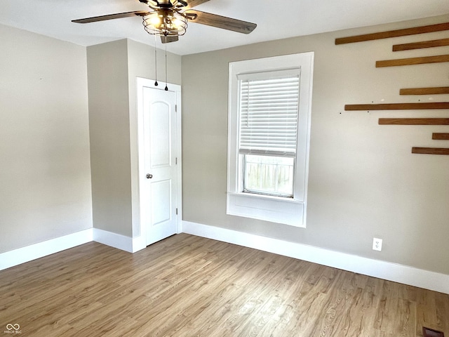 spare room with ceiling fan, wood finished floors, and baseboards