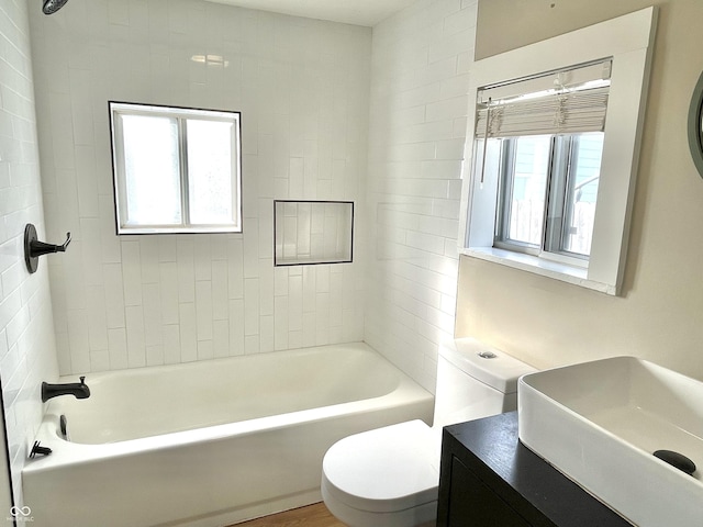 full bath featuring a wealth of natural light, shower / bathing tub combination, vanity, and toilet