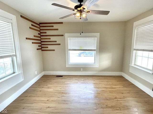 spare room with a wealth of natural light, visible vents, and light wood finished floors