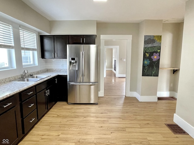 kitchen with visible vents, stainless steel fridge with ice dispenser, light countertops, light wood-type flooring, and a sink