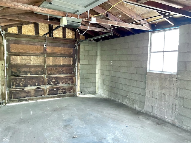 garage with concrete block wall and a garage door opener