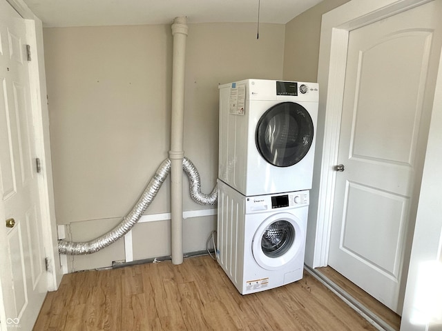 laundry room featuring stacked washer / dryer and light wood finished floors