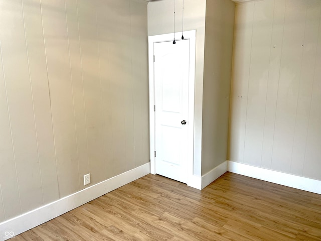 unfurnished room with light wood-style flooring and baseboards