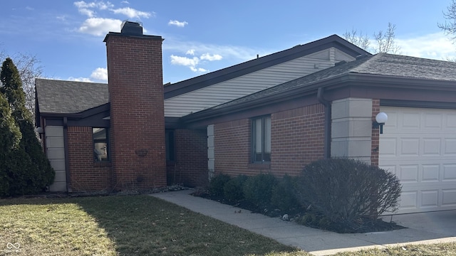 view of property exterior with brick siding, a chimney, a shingled roof, a lawn, and an attached garage