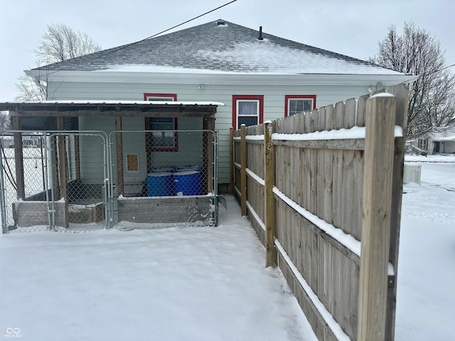 exterior space featuring fence and roof with shingles