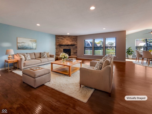 living room featuring dark hardwood / wood-style floors and a stone fireplace