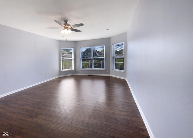 empty room with ceiling fan and dark hardwood / wood-style flooring