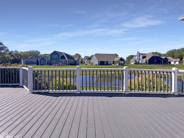 wooden terrace with a yard and a water view