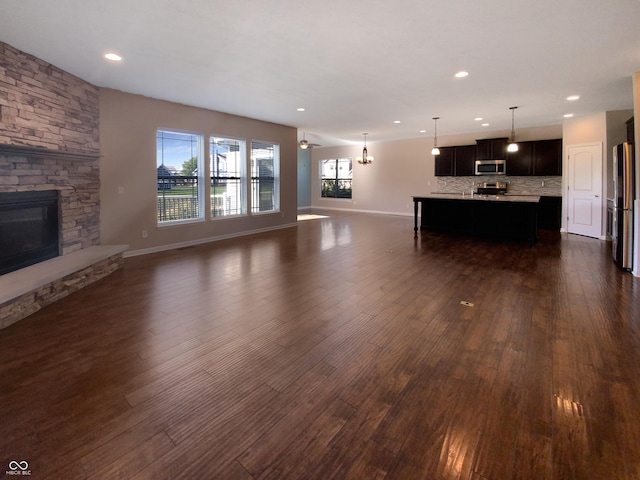 unfurnished living room featuring a fireplace and dark wood-type flooring