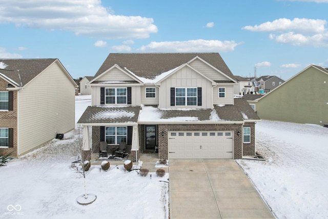 view of front of home featuring a garage, driveway, brick siding, and board and batten siding