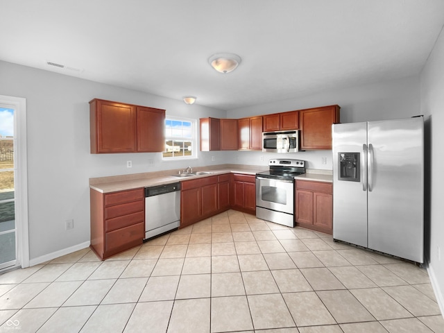 kitchen with light tile patterned floors, stainless steel appliances, and sink