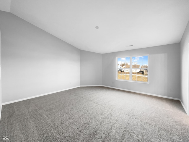 carpeted empty room with lofted ceiling