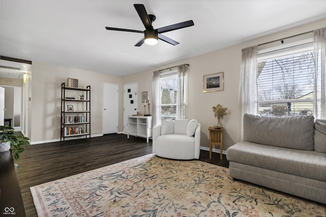 interior space with baseboards, dark wood-type flooring, and a ceiling fan