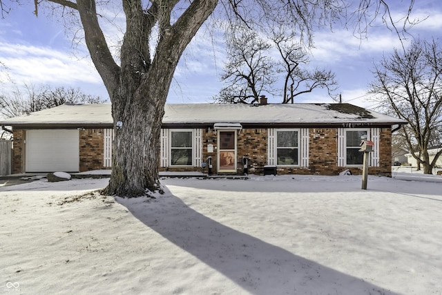 view of front facade with an attached garage, a chimney, and brick siding