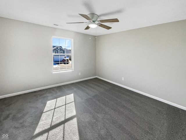 empty room featuring dark colored carpet and ceiling fan