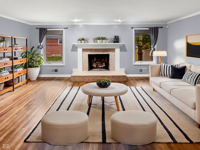 living room featuring crown molding, a high end fireplace, and hardwood / wood-style floors