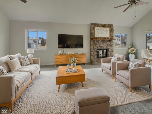 living area with a wealth of natural light, light carpet, ceiling fan, and a fireplace