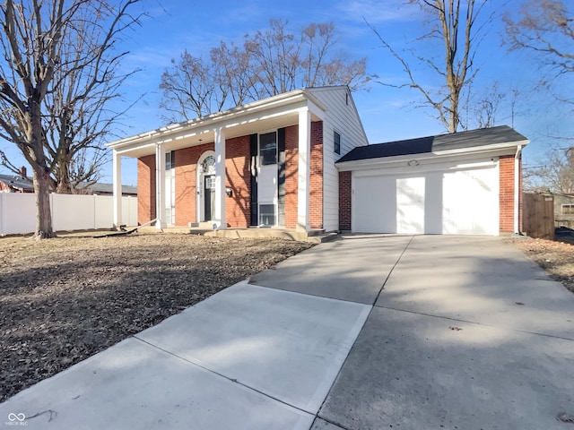 view of front facade featuring a garage, brick siding, driveway, and fence