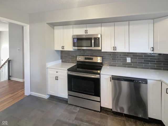 kitchen with stainless steel appliances, light countertops, white cabinetry, and decorative backsplash