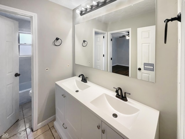 bathroom featuring baseboards, a sink, toilet, and double vanity