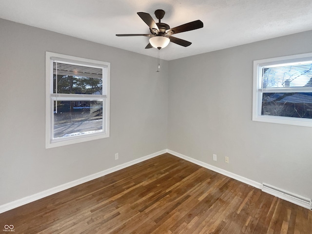 spare room featuring ceiling fan, visible vents, baseboards, and wood finished floors