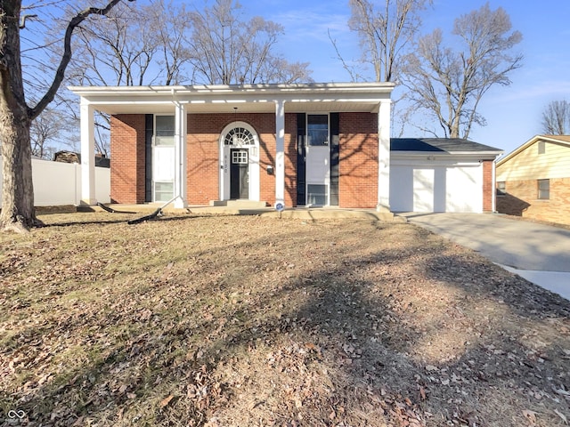 view of front of house featuring a garage, brick siding, driveway, and fence