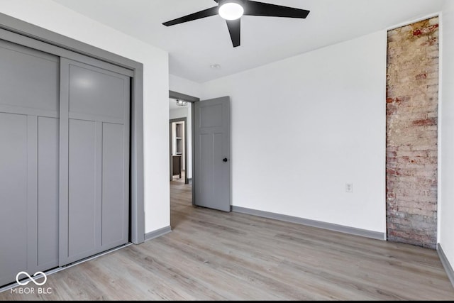 unfurnished bedroom with ceiling fan, light hardwood / wood-style floors, and a closet