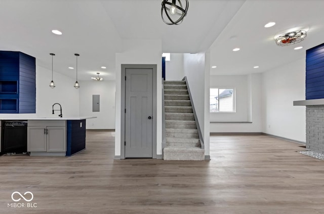 interior space with light hardwood / wood-style floors, pendant lighting, dishwasher, and electric panel