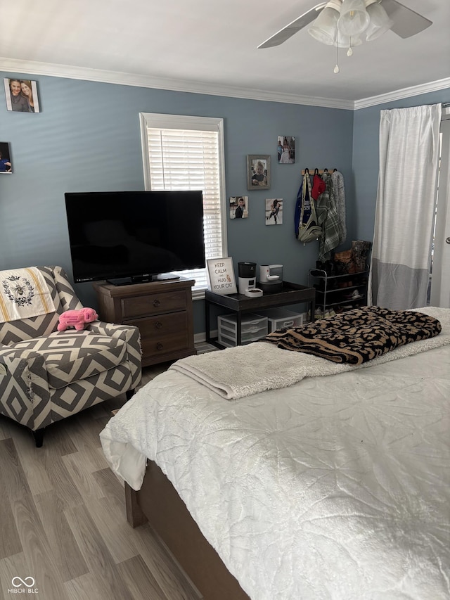 bedroom featuring ornamental molding, a ceiling fan, and wood finished floors