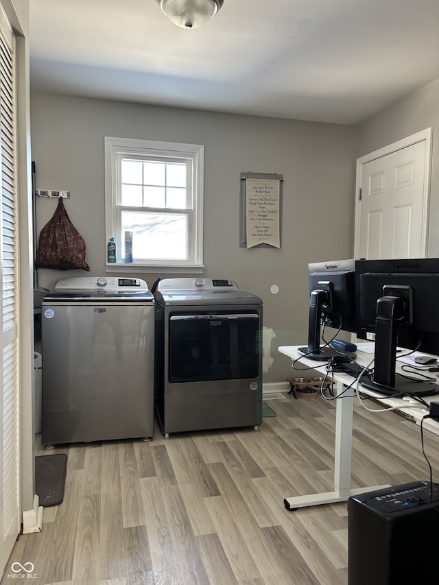 laundry area featuring light wood-style floors, laundry area, baseboards, and washing machine and clothes dryer