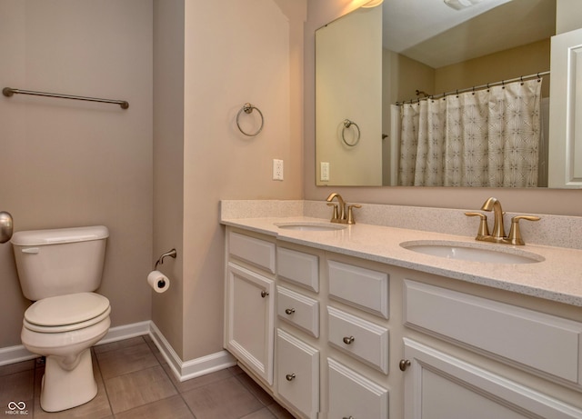 full bathroom with double vanity, baseboards, a sink, and tile patterned floors