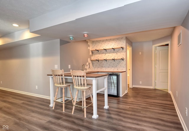 bar with decorative backsplash, wet bar, dark wood-style flooring, and baseboards