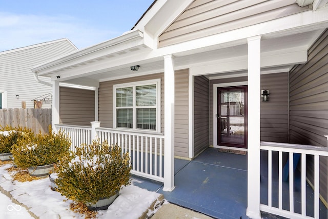 snow covered property entrance featuring a porch