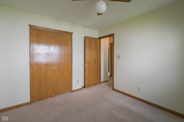 unfurnished bedroom with carpet floors, a ceiling fan, baseboards, and a closet