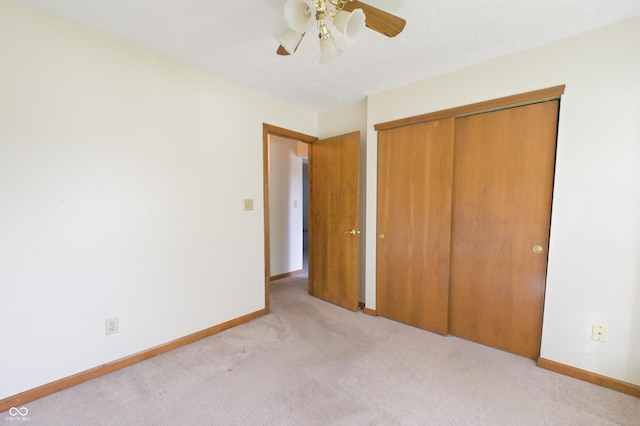 unfurnished bedroom with carpet floors, a ceiling fan, baseboards, and a closet