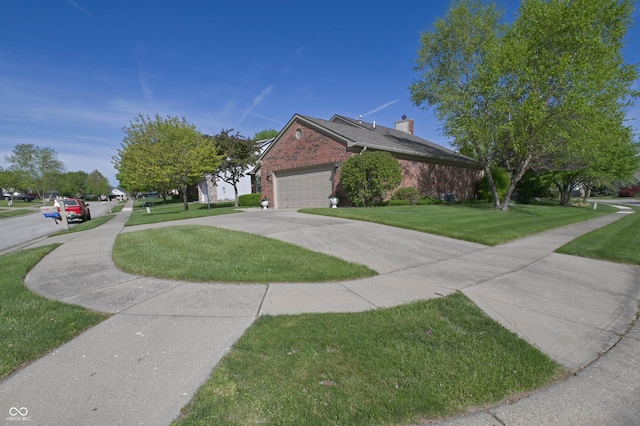 view of side of property featuring a garage, driveway, a chimney, brick siding, and a yard