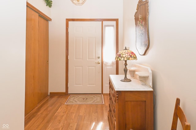 doorway to outside with baseboards and light wood-type flooring