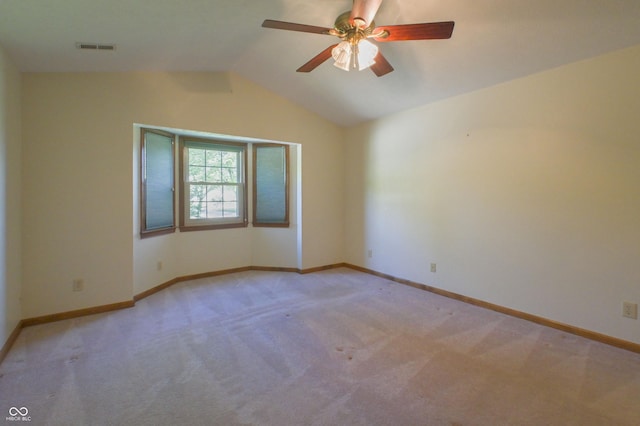 empty room with visible vents, ceiling fan, lofted ceiling, and light carpet