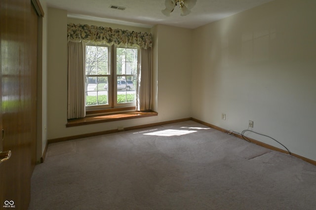 empty room with visible vents, carpet, and baseboards