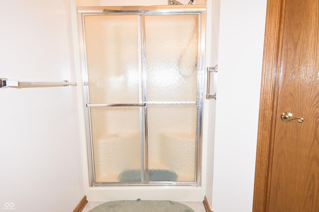full bathroom with baseboards and a shower stall