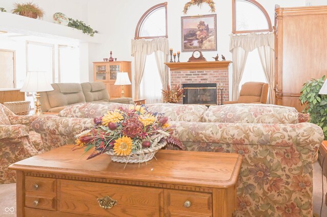 living area with a brick fireplace and a healthy amount of sunlight