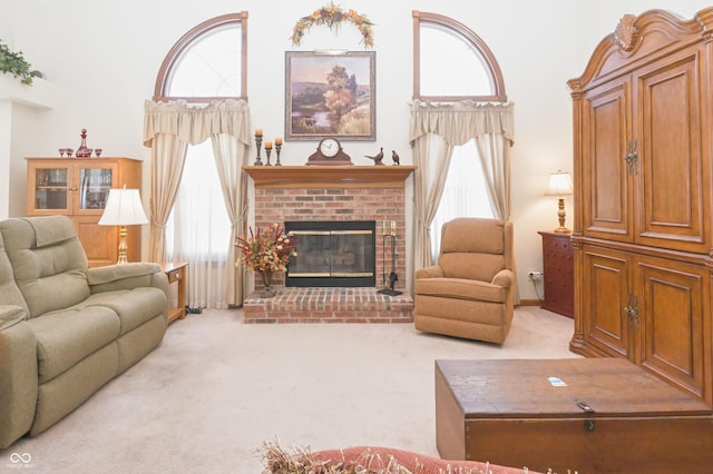 carpeted living room with a brick fireplace, a wealth of natural light, and a towering ceiling