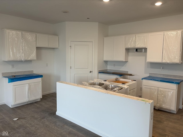 kitchen with white cabinets, dark wood-style floors, and a center island