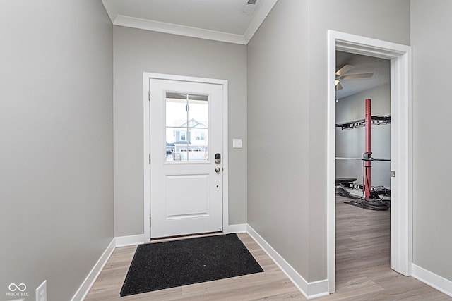 doorway to outside with light wood-style floors, ornamental molding, and baseboards