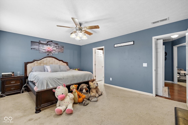 bedroom featuring a textured ceiling, carpet flooring, and ceiling fan